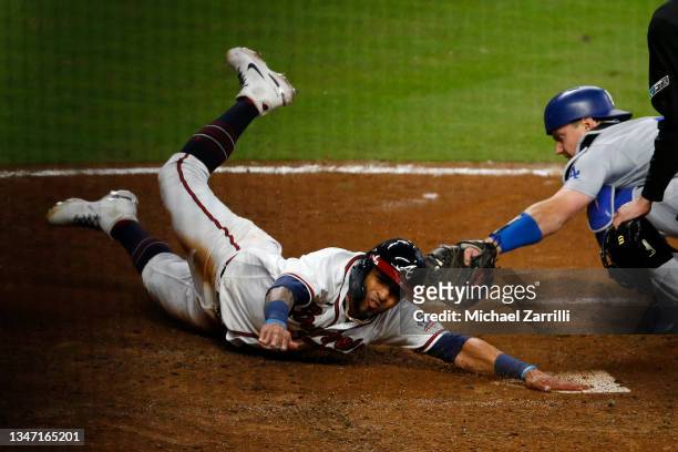 Eddie Rosario of the Atlanta Braves slides safely past Will Smith of the Los Angeles Dodgers to score in the eighth inning of Game Two of the...
