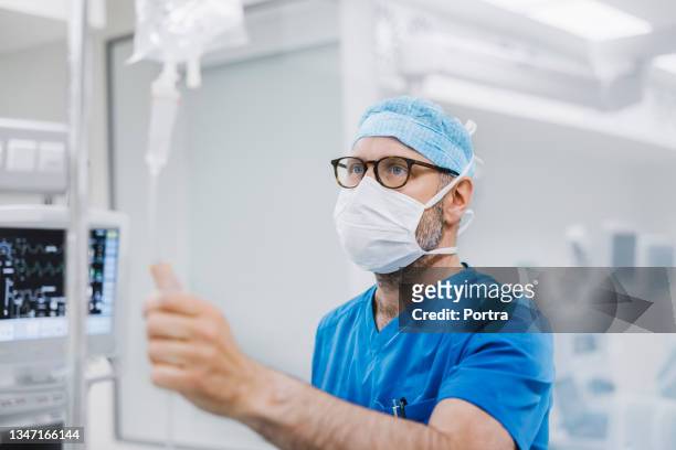 doctor examining iv drip in operating room - anesthetic 個照片及圖片檔