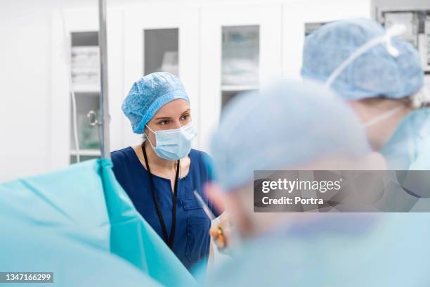 nurse discussing with doctors in operating room - life support stock pictures, royalty-free photos & images