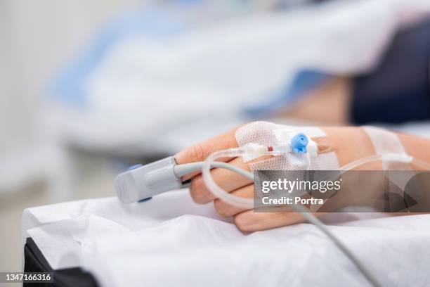 nahaufnahme medizinischer geräte an der hand des patienten - operationstisch stock-fotos und bilder