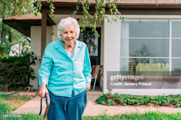 douce femme âgée de 100 ans debout à l’extérieur devant sa maison en été - centenaire et plus photos et images de collection