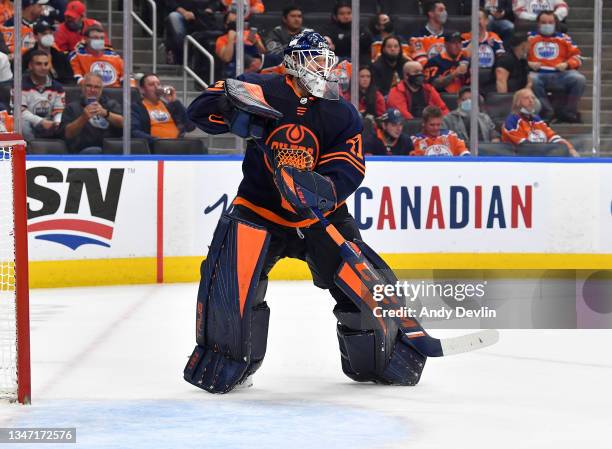 Mike Smith of the Edmonton Oilers plays the puck during the game against the Calgary Flames on October 16, 2021 at Rogers Place in Edmonton, Alberta,...