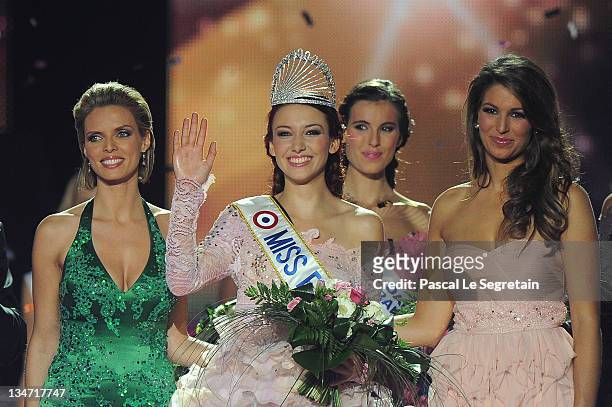 Miss France 2012 Delphine Wespiser waves as Sylvie Tellier director of the Miss France competition and Laury Thilleman stand on stage on December 3,...