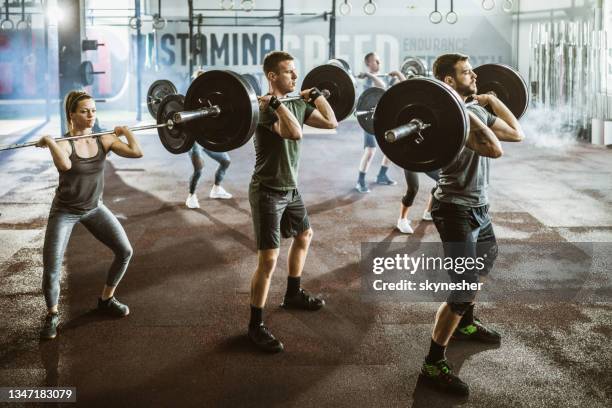 gruppe von sportlern, die in einem fitnessstudio krafttraining mit langhanteln haben. - snatch stock-fotos und bilder