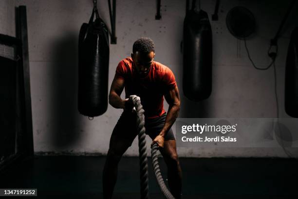 man with battle ropes in a gym - 体育館 ストックフォトと画像