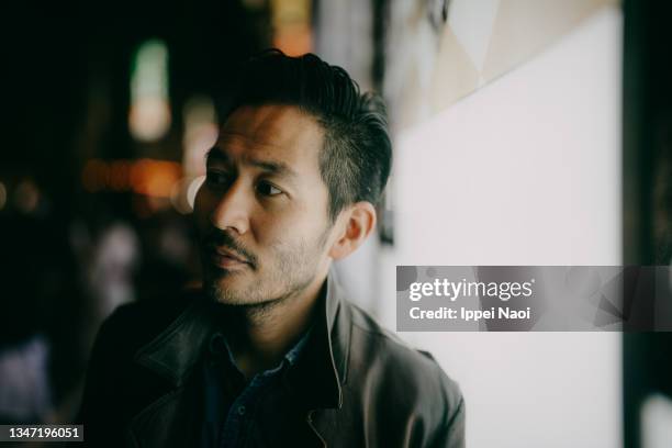 japanese man in leather jacket in tokyo at night - man 40 self confident stock pictures, royalty-free photos & images