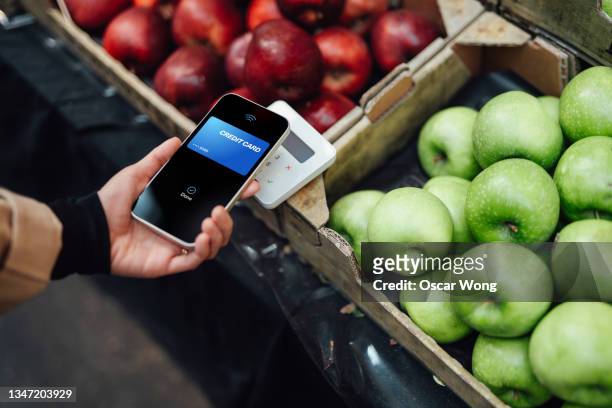 making contactless payment with smart phone at farmers market - paying stock-fotos und bilder