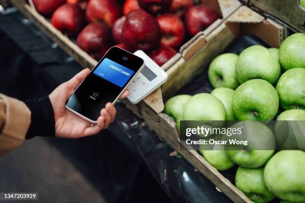 making contactless payment with smart phone at farmers market - card reader stockfoto's en -beelden