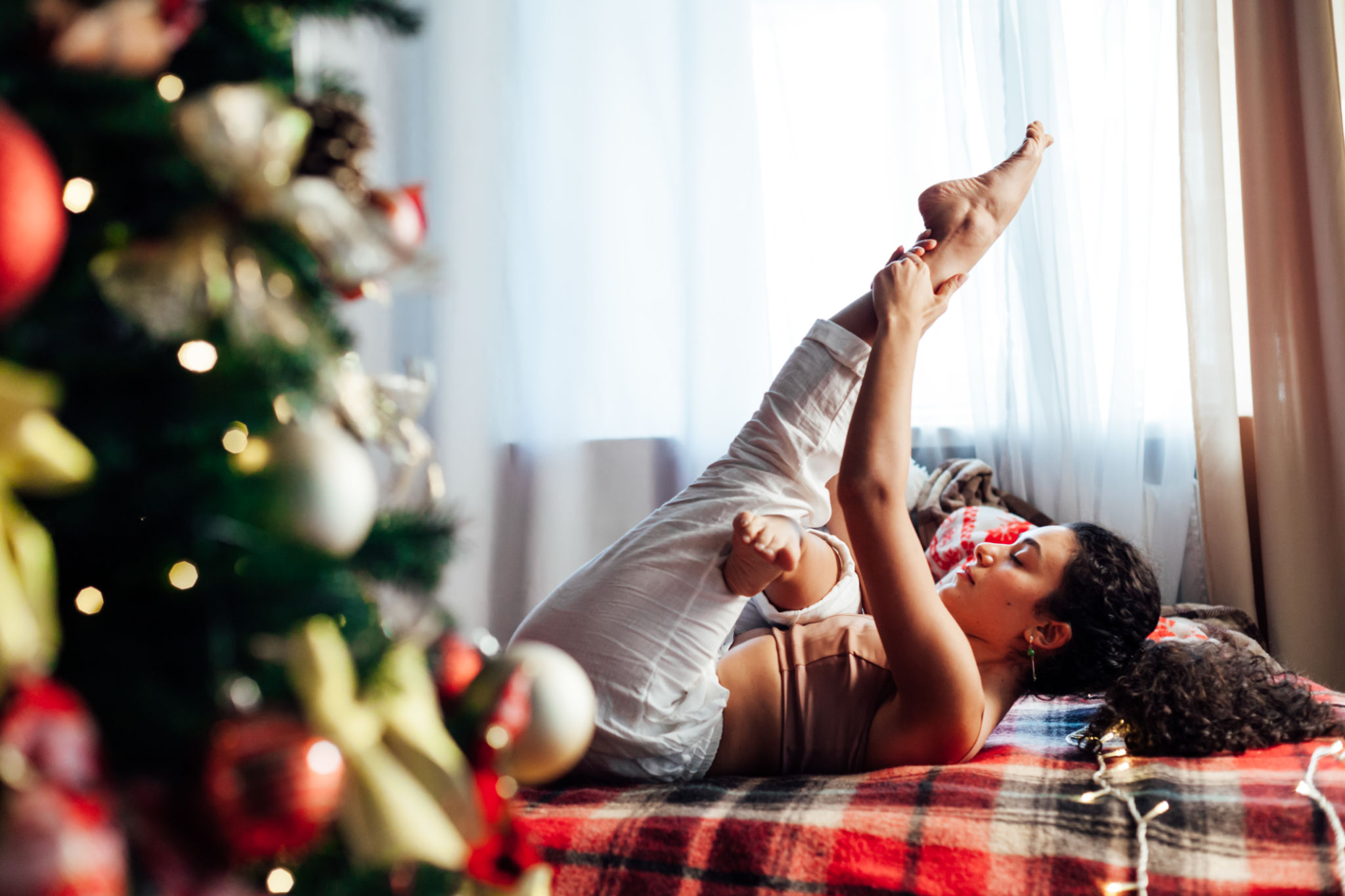 Beautiful woman yoga asana gymnastics at the Christmas tree with new year gifts Beautiful woman yoga asana gymnastics at the Christmas tree with new year gifts