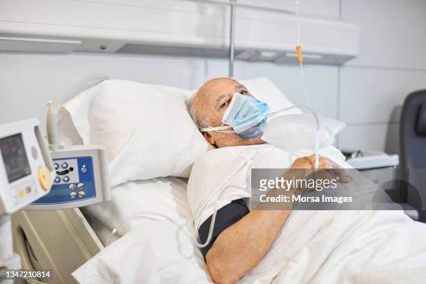 man on ventilator in hospital during covid-19 - patient on ventilator stock pictures, royalty-free photos & images