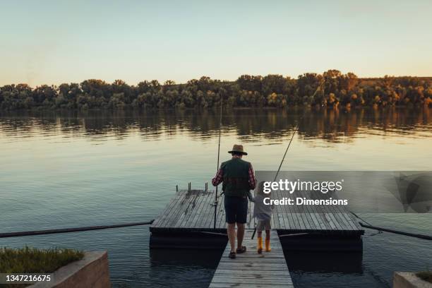 ragazza che tiene la mano del nonno e va a pescare sul ponte - molo foto e immagini stock