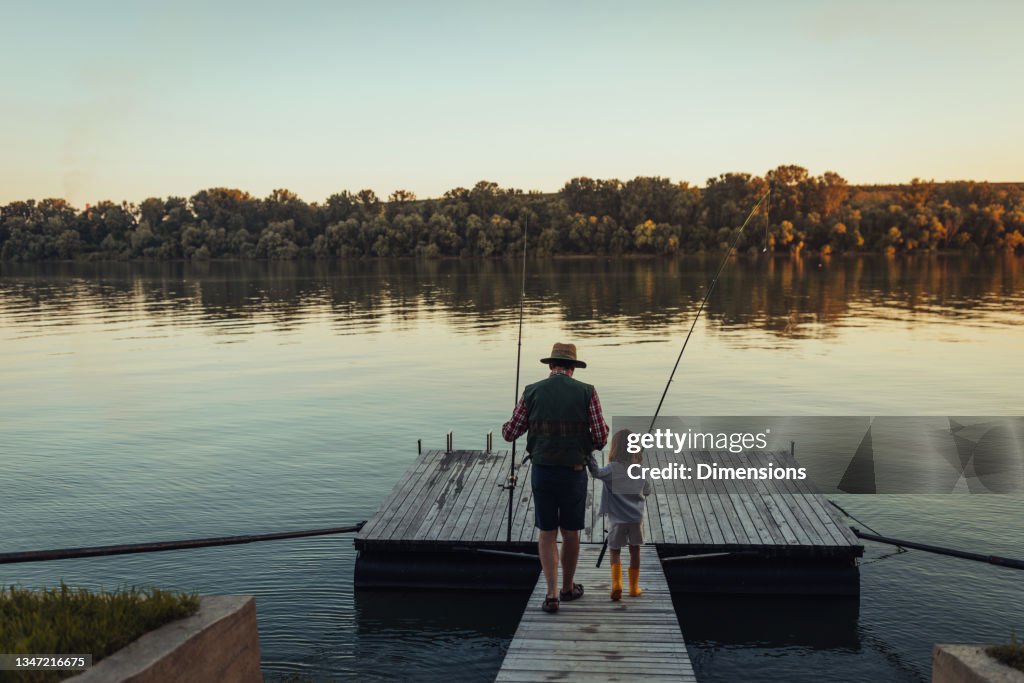 Girl Holding Grandfathers Hand And Going Fishing On The Deck High-Res Stock  Photo - Getty Images