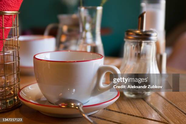 a mug of coffee or tea on a wooden table, in a cafe, restaurant or cafeteria. breakfast concept, business meetings, dates. coffee break. - pires imagens e fotografias de stock