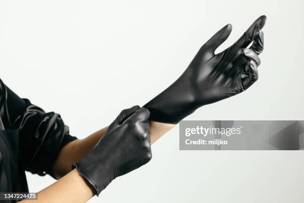 putting on latex protective glove - putting gloves stock pictures, royalty-free photos & images