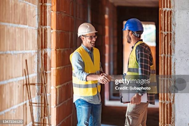 construction workers shaking hands at a construction site - handshake site stock pictures, royalty-free photos & images