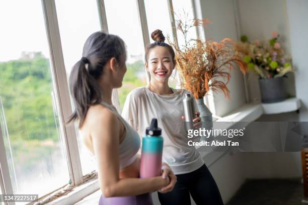 young asian chinese girl smiling with water bottle stock photo - yoga instructor stock pictures, royalty-free photos & images