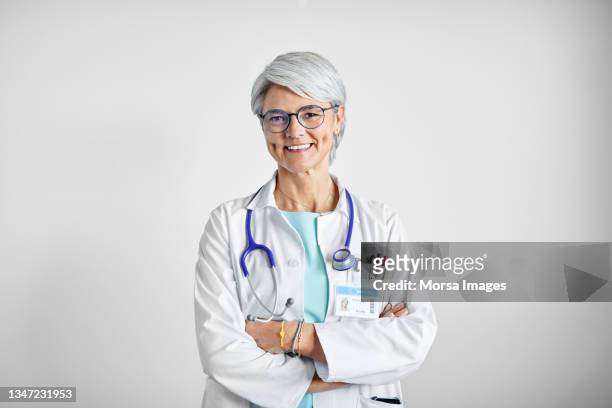 smiling female doctor against white background - female doctor on white stock pictures, royalty-free photos & images