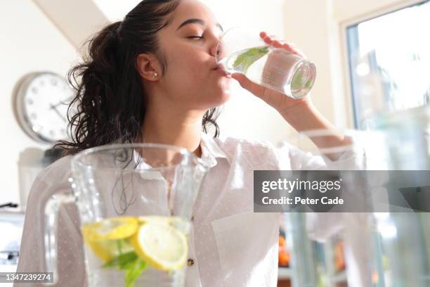 woman drinking glass of water - lemon slice stock pictures, royalty-free photos & images