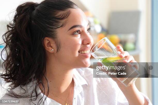 woman holding glass of water - lemon soda fotografías e imágenes de stock