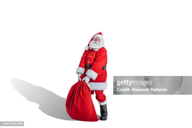 christmas santa claus picks up a big bag of gifts on a white background - santa sack stock-fotos und bilder