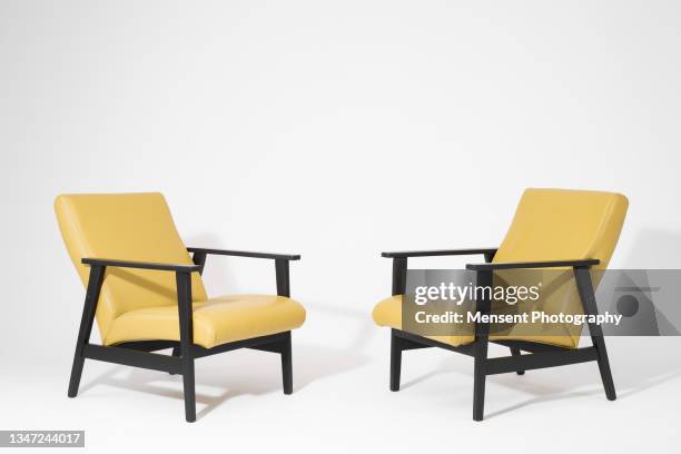 two modern yellow armchairs isolated on a white background - white hat fashion item stock-fotos und bilder