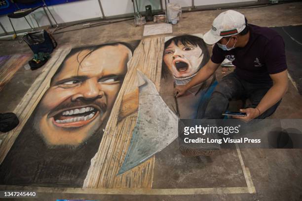 Artists make murals referencing movies and comics on the ground during the fourth day of the SOFA 2021, a fair aimed to the geek audience in Colombia...