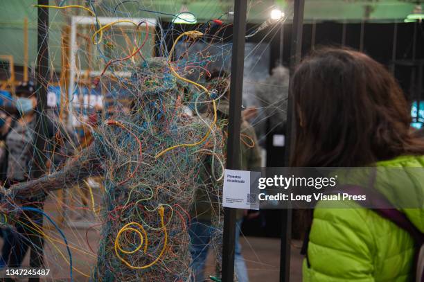 Attendees take a look at a sculpture made out of computer wiring during the first day of the SOFA 2021, a fair aimed to the geek audience in Colombia...