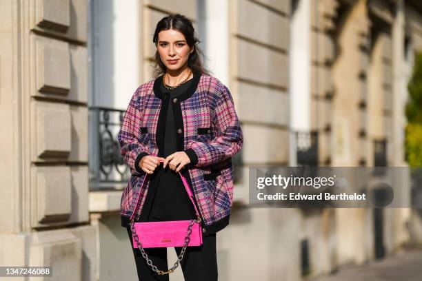 Katie Giorgadze wears front slit black flared leggings from Bershka, a black halter neck bodysuit from Zara, an oversized pink tweed jacket with...