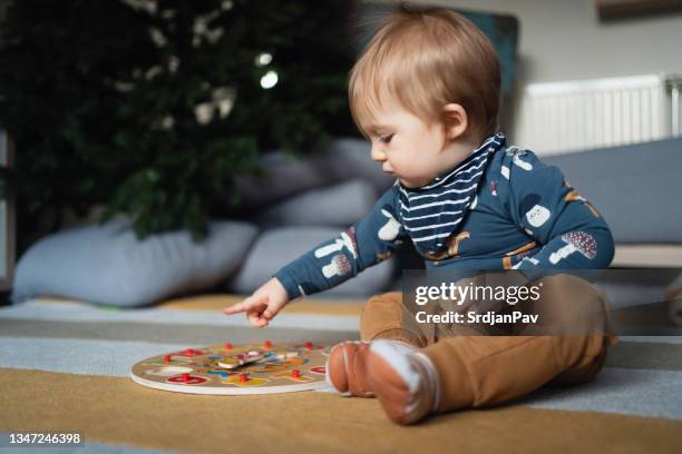 curieux garçon en bas âge jouant avec son jouet de noël éducatif - bébé jeu photos et images de collection