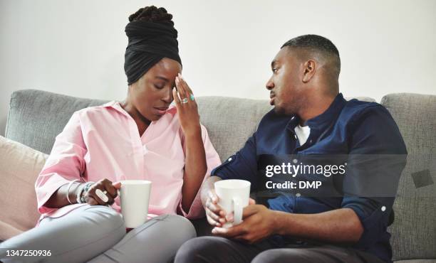 shot of a young couple spending discussing an issue on the sofa at home - cheating husband stock pictures, royalty-free photos & images