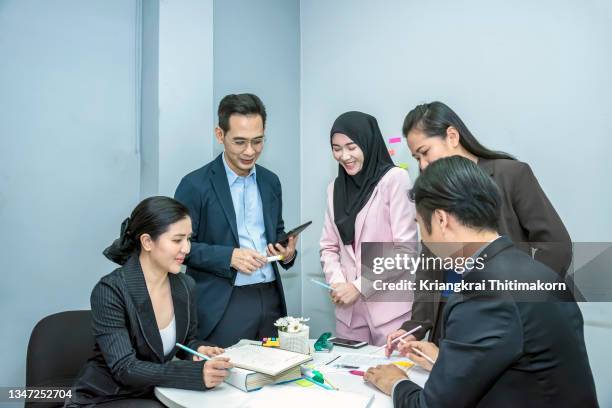 a small group of professional colleagues are discussing about work in the meeting room. - small business meeting in asia photos et images de collection