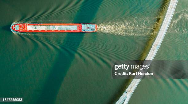 an elevated view of commercial barge sailing under the nescio bridge in amsterdam - stock photo - barge fotografías e imágenes de stock