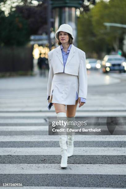 Guest wears a white fluffy bob / hat, a blue and white small checkered pattern shirt, a white cropped blazer jacket, a matching white high waist...