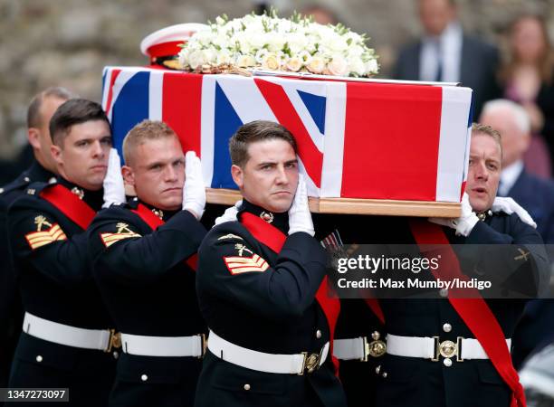 Major General Matthew Holmes's coffin, draped in a union flag and bearing his sword, medals and Royal Marines cap, is carried by Royal Marines...