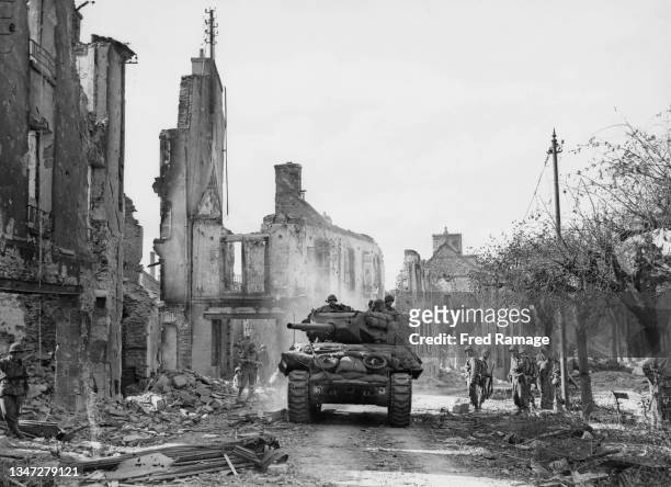 Wolverine tank destroyers from the 6th Armoured Division, VIII Corps United States Third Army advance through the shell damaged town of Lambezellec...