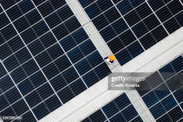 high angle view of engineer holding digital tablet to analysis data of photovoltaic panel system during installation on roof. - overhead stock-fotos und bilder