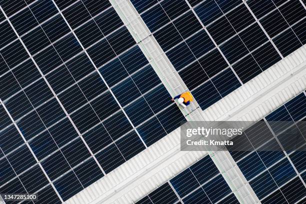 high angle view of engineer holding digital tablet to analysis data of photovoltaic panel system during installation on roof. - people aerial view stockfoto's en -beelden