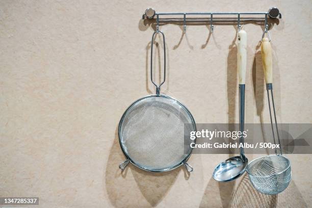 directly above shot of kitchen utensils hanging on wall - sieve stock pictures, royalty-free photos & images