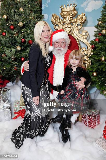 Tori Spelling poses with daughter Stella on Santa's lap at the Working Elves' First Annual Santa's Secret Workshop Benefitting LA Family Housing at...