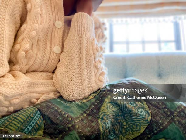 african-american woman holds her head in hand while experiencing a headache - chronic fatigue stock-fotos und bilder