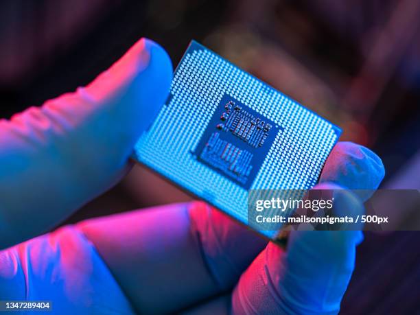 close-up of person holding computer chip - elektronik industrie stock-fotos und bilder