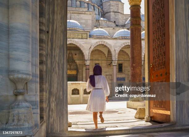 young beautiful muslim woman posing in courtyard of suleymaniye mosque in istanbul, turkey - internal conflict stock pictures, royalty-free photos & images