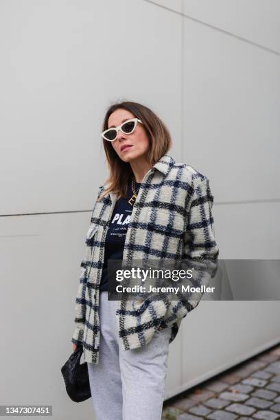 Elise Soho wearing Celine beige shades, closed beige and blue jacket, Hey Soho navy blue sweater and grey pants, Bottega Veneta black mini Jodie on...