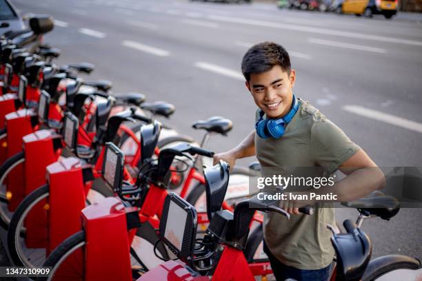 high angle view of a happy young mixed race man renting an electric bicycle - barcelona tours stock pictures, royalty-free photos & images