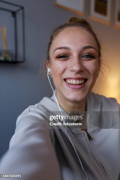 joyful teenage girl smiling at camera during a video conference with a friend - teenage girl selfie stock pictures, royalty-free photos & images