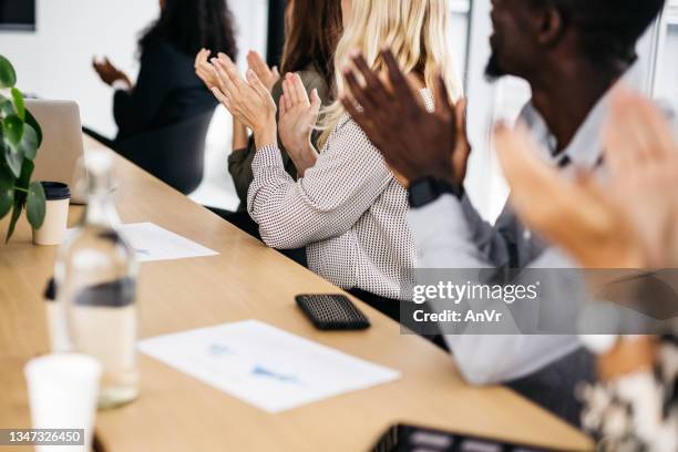 close-up of co-workers clapping at a meeting. - face covered stock pictures, royalty-free photos & images