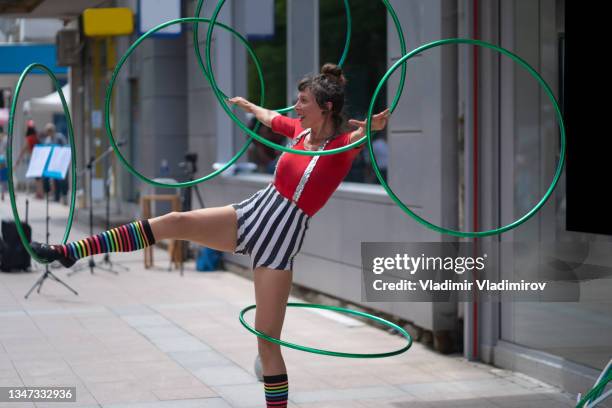 a street performer twirling hoops in the street - acrobatics gymnastics stockfoto's en -beelden