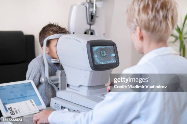 ophthalmologist completing an eye test on a boy - myopia 個照片及圖片檔