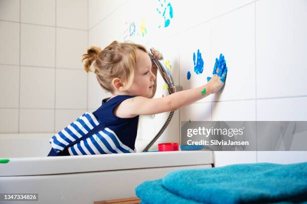 toddler boy finger painting in bathroom - finger painting stock pictures, royalty-free photos & images