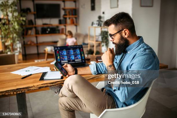 cryptocurrency investor trading at home using his laptop - investment imagens e fotografias de stock